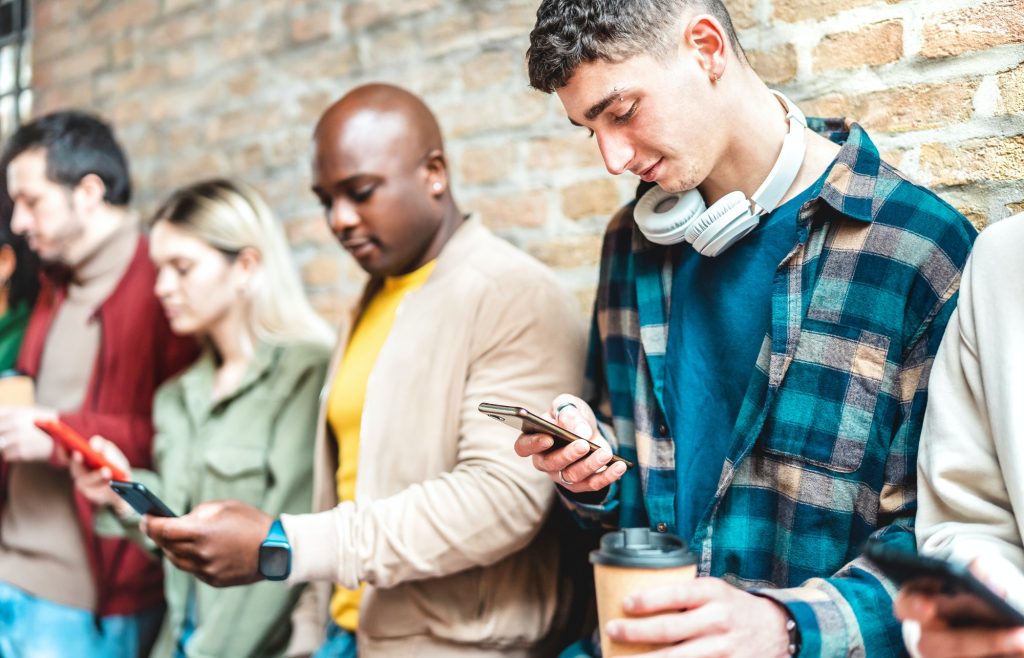 Multicultural people group using smartphone with coffee at university college break